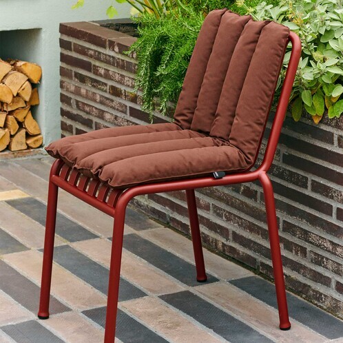 HAY Palissade Gartenstuhl aus rotem Stahl mit braunen Kissen, modernes Design, auf Terrassenfliesen neben Pflanzen. - Palissade Weiches Steppkissen 80x40cm