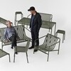 Zwei Männer betrachten HAY Palissade Gartenmöbel aus Metall in olivgrünem Design, moderne Außenraumgestaltung. - Palissade Gartenhocker