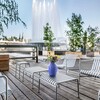 HAY Palissade Outdoor-Möbel aus Metall auf Holzterrasse mit Springbrunnen im Hintergrund. - Palissade Gartenhocker Feuerverzinkt