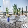 HAY Palissade Outdoor-Möbel aus Metall auf Holzdeck mit Springbrunnen und Pflanzen im Hintergrund. - Palissade Garten Loungesessel niedrig Feuerverzinkt 2er Set