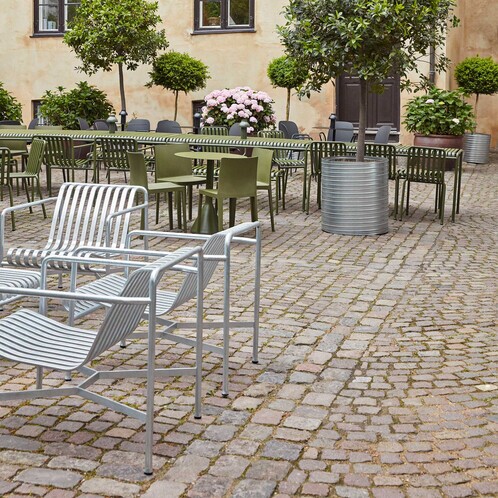 HAY Palissade Kollektion mit outdoor Stühlen und Tischen aus Metall in einem gemütlichen Hof mit Kopfsteinpflaster und Pflanzen. - Palissade Garten Loungesessel niedrig Feuerverzinkt 2er Set
