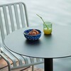 HAY Palissade runder Tisch aus Metall mit Stuhl am Wasser, blaue Keramikschale und Saftglas, moderne Outdoor-Möbel. - Palissade Gartenstuhl 4er Set
