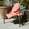 Grüner HAY Palissade Gartenstuhl aus Metall mit korallenroter Decke, neben Terrakottatopf im Freien. - Palissade Garten Loungesessel niedrig 2er Set