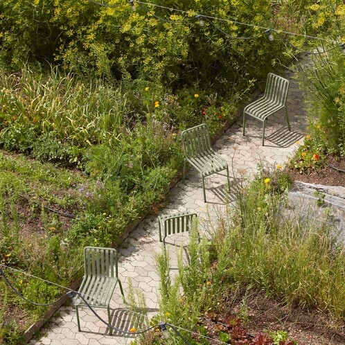 HAY Palissade Gartenstühle aus Metall in grüner Farbe, elegant im Freien auf einem gepflasterten Weg arrangiert. - Special Edition Palissade Gartenstuhl