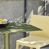HAY Palissade Kollektion Außenmöbel in Olivgrün und Hellgelb mit Schattenspiel auf Tischplatte, neben Betonwand. - Palissade Cone Gartentisch 65x65cm