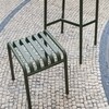 HAY Palissade Kollektion grüner Metallstuhl auf Mosaikpflaster, modernes Design, Außenmöbel, langlebiges Material. - Palissade Gartenhocker