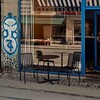 HAY Palissade Kollektion im Außenbereich: schwarze Metallstühle und Tisch vor Café mit blauer Markise und Spiegelung. - Palissade Gartenstuhl 4er Set